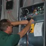 A technician tuning up air conditioner